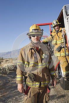 Fireman With Coworker Standing At The Fire Brigade's Door photo