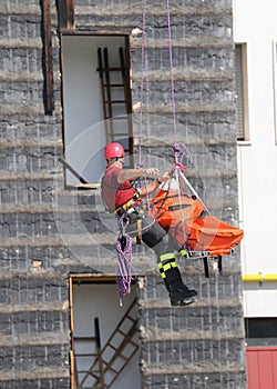 fireman during an exercise carries the stretcher with the climbing rope