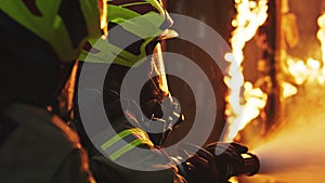 Fireman extinguish fire with the hose. Burning house fire drill