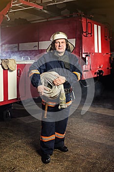 Fireman firefighter in action standing near a firetruck. Emer