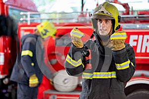 Fireman or firefighter stand and show some action look like he report the situation of some events for other people during the