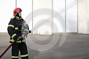 fireman holds and adjust nozzle and fire hose photo