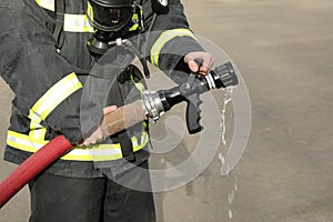 fireman holds and adjust nozzle and fire hose photo