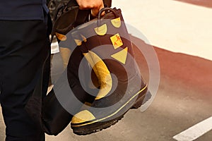 Fireman holds rubber protective fire fighting boots