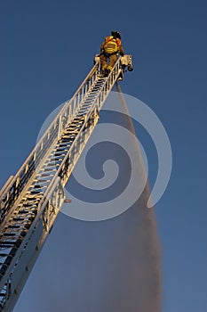 Fireman on Ladder Truck Spray Water on Fire