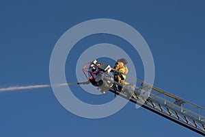 Fireman on Ladder Truck Spray Water on Fire