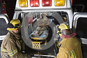 Fireman Looking At Patient And EMT Doctor