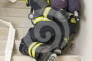 A fireman`s hand opens a cylinder with compressed air for breathing in a smoky room