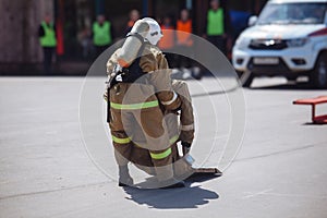 Fireman in uniform is dragging a mannequin on training