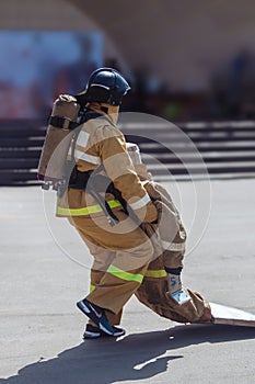 Fireman in uniform is dragging a mannequin on training