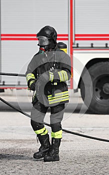 fireman with uniform helmet and respirator with oxygen cylinders