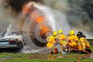 Fireman using water and extinguisher,fireman using water and extinguisher car is on fire,