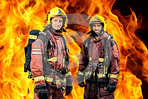 Firemen against burning background.