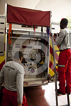 Firemen at the back side of a fire truck