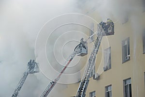 Firemen extinguish fire on fire trucks ladders - photo