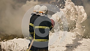 Firemen extinguishing fire in field