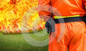 Firemen standing in front of a big flame