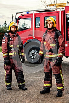 Firemen standing next to fire truck.