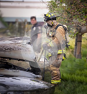 Firemen working at scene of burned car