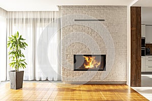 Fireplace on brick wall in bright living room interior of house