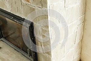 Fireplace close up in unfinished living room, home renovation concept. Decorating fireplace with natural stone and wooden mantel
