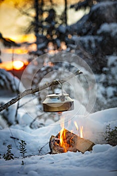 Fireplace and coffee pot in Finland. There is a sunset in the background.