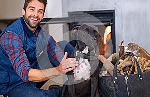 Fireplace, dog and portrait of man with fire in home for heat, warmth and light in winter. Flame, wood and person with
