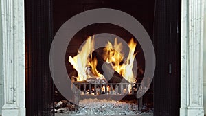 Fireplace with fire sparking, A roaring fire with fireguard, in a domestic house fireplace UK