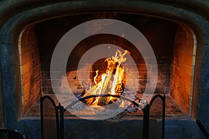 fireplace with firewood and a fire burning. the concept of home comfort and warmth.