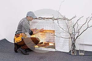 Fireplace installing in white brick wall.