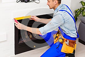 Fireplace installing in white brick wall.