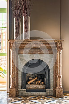 Fireplace made of heat-resistant bricks is lined with marble material of different textures and colors on top creating