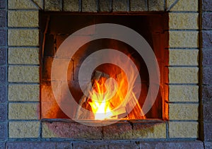 Fireplace made of silicate bricks. A fire is burning in the fireplace