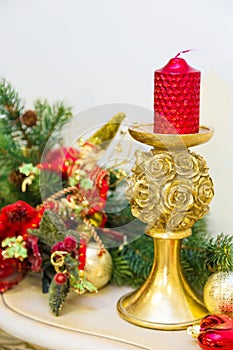 A fireplace mantle is decorated for Christmas with garland, lights, a bow and other decorations