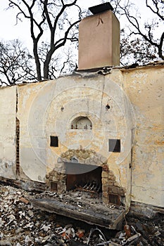 Only a fireplace stands amidst the charred destruction of a house fire.