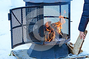 Fireplace in winter season charged with firewood, in the burning process.