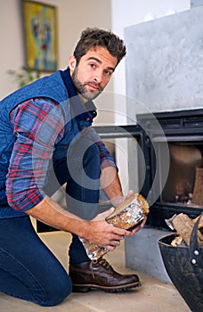 Fireplace, wood and portrait of man in home for heat, warmth and light in winter. Flame, burning hearth and person with
