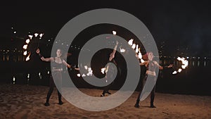 Fireshow artists juggling with fire on riverside