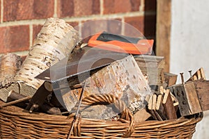 Firewood. Basket of hand sawn fire wood logs and saw