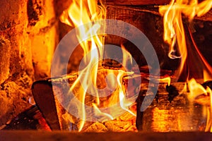 Firewood burning in fire burns in the fireplace. The brick oven gives heat and heat from the burnt logs. Burning coals and flames