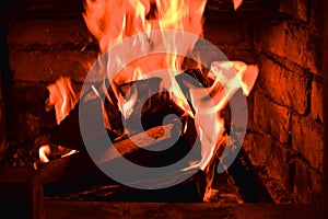 Firewood burning in fire burns in the fireplace. The brick oven gives heat and heat from the burnt logs. Burning coals and flames