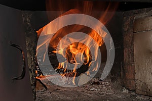 firewood burns with a bright orange flame in the stove. horizontal photo.