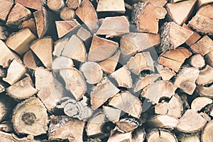 Firewood or fuelwood stacked by a wall. Texture woodpile