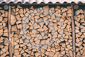 Firewood or fuelwood stacked by a wall. Texture woodpile