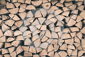 Firewood or fuelwood stacked by a wall. Texture woodpile