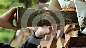 Firewood. Heating season.solid fuel.Male hands pulling a log from a woodshed.Heating season in Europe.