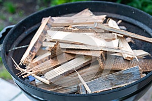 Firewood for lighting in the barbecue grill. Grill for frying steaks in the backyard of the house. Family pastime. Selective focus