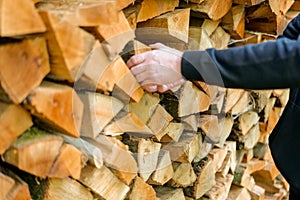 Firewood and mens hands close-up. solid fuel.Male hands pulling a log from a woodshed. Heating season.Heating season