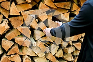 Firewood and mens hands close-up. solid fuel.Male hands pulling a log from a woodshed. Prices for firewood and heating.