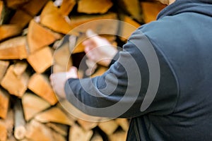 Firewood. solid fuel.Male hands pulling a log from a woodshed. Heating season.Heating season.Prices for firewood and